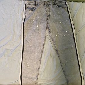 Blue jeans with paint splatter and black and white strips